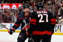 Hokejista Caroliny Hurricanes Nikolaj Ehlers (27) sa te&scaron;&iacute; z g&oacute;lu, ktor&yacute; strelil jeho spoluhr&aacute;č Andrej Svečnikov (37). FOTO: TASR/AP