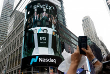Ľudia sa zhromaždili, aby sledovali živ&yacute; prenos s gener&aacute;lnym riaditeľom SpaceX Elonom Muskom v deň prvej verejnej ponuky akci&iacute; spoločnosti SpaceX na burze Nasdaq. FOTO: Reuters