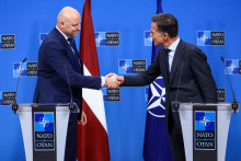 Loty&scaron;sk&yacute; premi&eacute;r Andris Kulbergs si pod&aacute;va ruku s gener&aacute;lnym tajomn&iacute;kom NATO Markom Ruttem. FOTO: Reuters