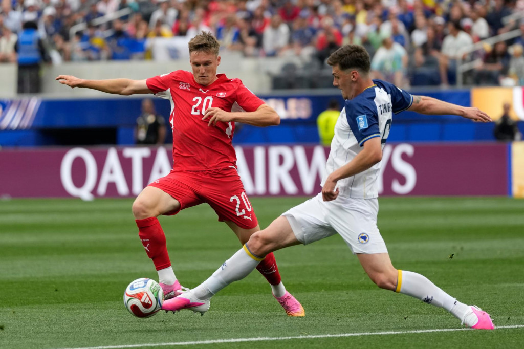 Futbalista Bosny Benjamin Tahirovič (vpravo) a hr&aacute;č &Scaron;vajčiarska Michel Aebischer bojuj&uacute; o loptu počas z&aacute;pasu B-skupiny na majstrovstv&aacute;ch vo futbale v americkom meste Inglewood 18. j&uacute;na 2026. FOTO: TASR/AP