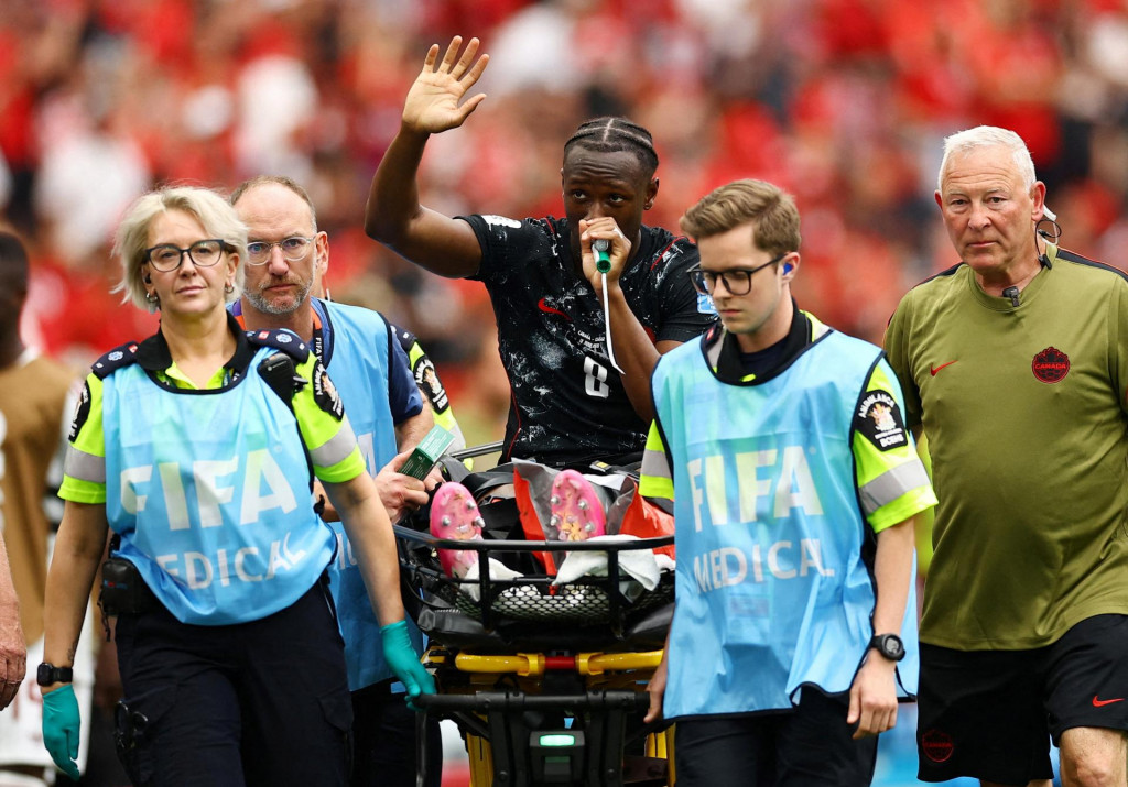 Kanadsk&yacute; hr&aacute;č Ismael Kone m&aacute;va publiku, keď dost&aacute;va kysl&iacute;k po tom, čo ho po zranen&iacute; odn&aacute;&scaron;aj&uacute; na nosidl&aacute;ch. FOTO: Reuters