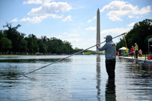 Zamestnanec Spr&aacute;vy n&aacute;rodn&yacute;ch parkov USA pracuje na odstraňovan&iacute; rias v odrazovom baz&eacute;ne Lincolnovho pam&auml;tn&iacute;ka. FOTO: Reuters