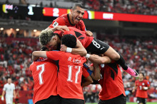 Egyptsk&yacute; hr&aacute;č Mahmoud Trezeguet oslavuje so spoluhr&aacute;čmi. FOTO: Reuters