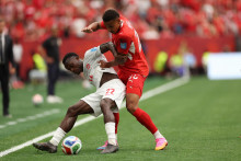 Futbalista Kanady Richie Laryea (vľavo) a hr&aacute;č &Scaron;vajčiarska Luca Jaquez bojuj&uacute; o loptu počas z&aacute;pasu B-skupiny &Scaron;vajčiarsko &ndash; Kanada na majstrovstv&aacute;ch sveta vo futbale vo Vancouveri. FOTO: TASR/AP