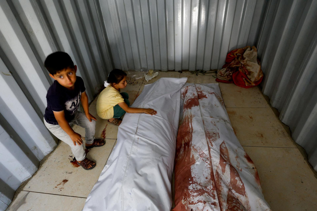 Deti Palest&iacute;nčana Ahmada Abu Heena sa z&uacute;častňuj&uacute; pohrebu svojho syna a syna jeho brata. FOTO: REUTERS