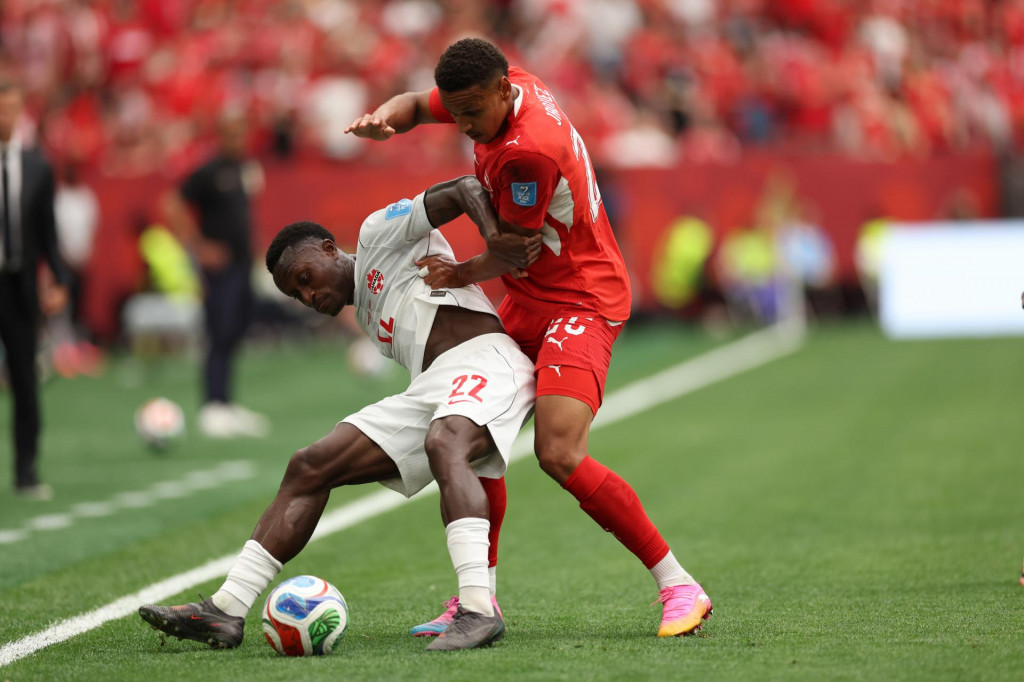 Futbalista Kanady Richie Laryea (vľavo) a hr&aacute;č &Scaron;vajčiarska Luca Jaquez bojuj&uacute; o loptu počas z&aacute;pasu B-skupiny &Scaron;vajčiarsko &ndash; Kanada na majstrovstv&aacute;ch sveta vo futbale vo Vancouveri. FOTO: TASR/AP