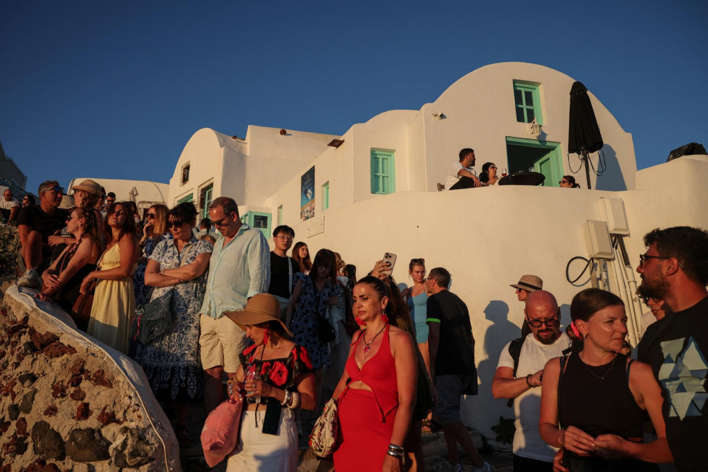 Turisti sa 23. j&uacute;na zhromaždili pri pozorovan&iacute; ikonick&eacute;ho z&aacute;padu slnka v dedine Oia na ostrove Santorini. FOTO: Reuters