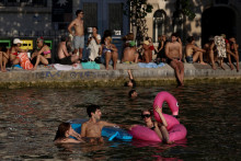 Ľudia pl&aacute;vaj&uacute; v kan&aacute;li Saint-Martin v Par&iacute;ž po tom, čo bolo verejn&eacute; k&uacute;panie povolen&eacute; v niektor&yacute;ch oblastiach kv&ocirc;li vysok&yacute;m teplot&aacute;m. FOTO: Reuters