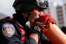 Hasič krič&iacute; cez hasičsk&uacute; r&uacute;ru na ľud&iacute; pod troskami zr&uacute;tenej budovy po zemetraseniach, ktor&eacute; zasiahli Venezuelu. FOTO: Reuters
