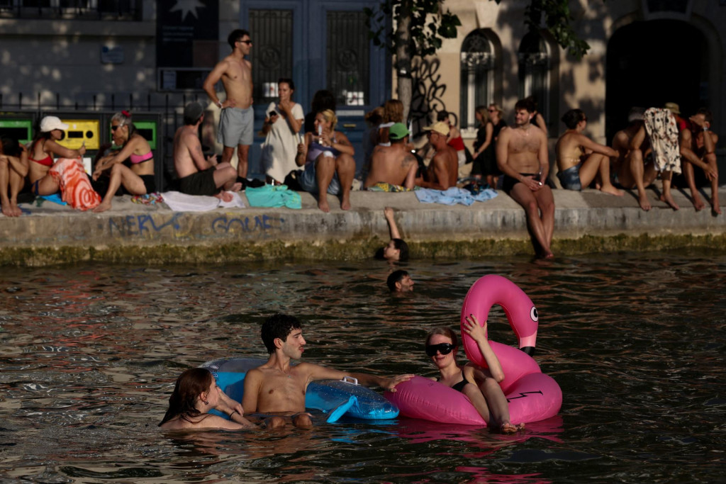 Ľudia pl&aacute;vaj&uacute; v kan&aacute;li Saint-Martin v Par&iacute;ž po tom, čo bolo verejn&eacute; k&uacute;panie povolen&eacute; v niektor&yacute;ch oblastiach kv&ocirc;li vysok&yacute;m teplot&aacute;m. FOTO: Reuters