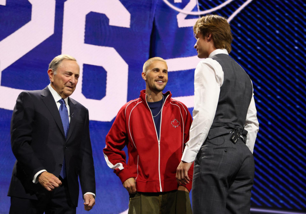 Gavin McKenna s komis&aacute;rom NHL Garym Bettmanom a spev&aacute;kom Justinom Bieberom. FOTO: Reuters