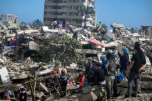 Z&aacute;chran&aacute;ri, dobrovoľn&iacute;ci a obyvatelia hľadaj&uacute; pozostal&yacute;ch v trosk&aacute;ch zr&uacute;ten&yacute;ch budov v Caraballede v &scaron;t&aacute;te La Guaira vo Venezuele. FOTO: Reuters