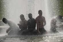 Ľudia sa osviežuj&uacute; vo font&aacute;ne Trocadero pri Eiffelovej veži počas vlny hor&uacute;čav v Par&iacute;ži 24. j&uacute;na 2026. FOTO: TASR/AP