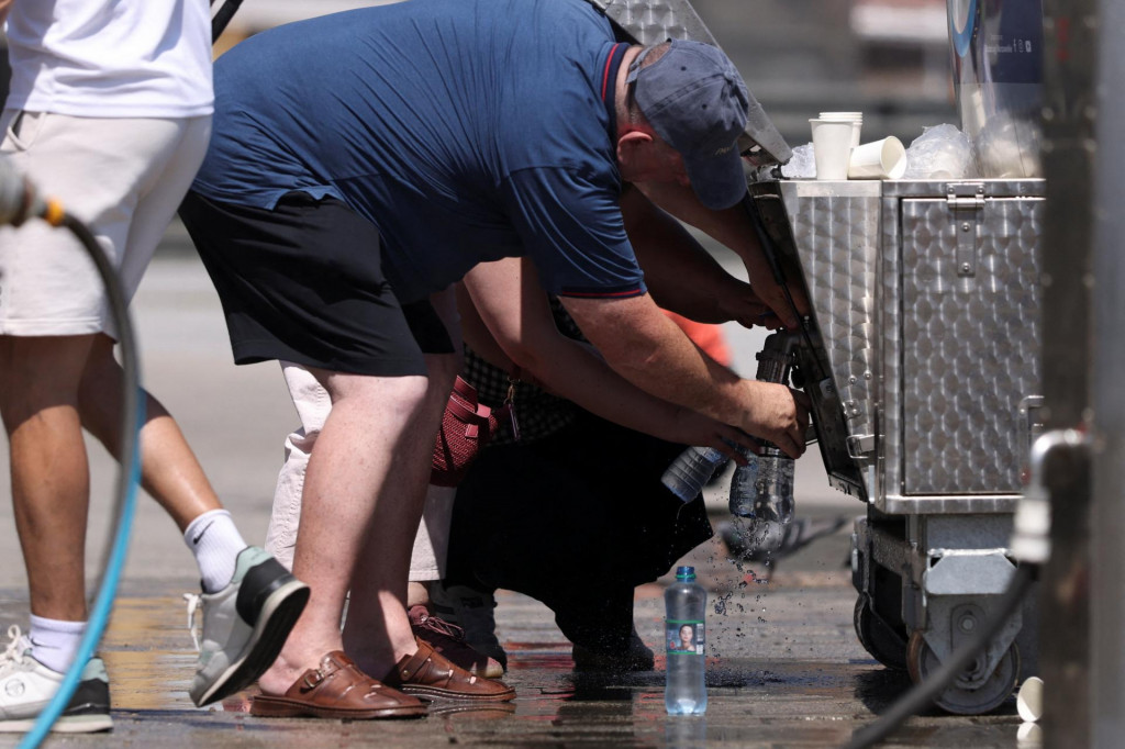 Ľudia plnia fľa&scaron;e z cisterny, ktor&aacute; poskytuje bezplatn&uacute; vodu a ktor&uacute; mesto zriadilo kv&ocirc;li vlne hor&uacute;čav vo Var&scaron;ave. FOTO: Reuters