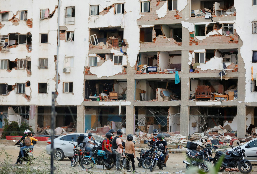 Ľudia sa pozeraj&uacute; na budovu zničen&uacute; zemetraseniami, ktor&eacute; zasiahl Venezuelu. FOTO: Reuters