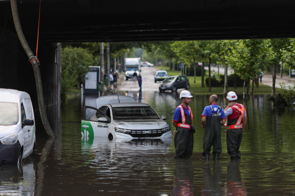 Pracovn&iacute;ci sleduj&uacute; odčerp&aacute;vanie dažďovej vody zo zatopen&eacute;ho železničn&eacute;ho podjazdu v severnej Bukure&scaron;ti. FOTO: Reuters