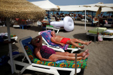 Turisti sa opaľuj&uacute; na pl&aacute;ži v Torremolinos neďaleko Malagy v južnom &Scaron;panielsku. FOTO: Reuters
