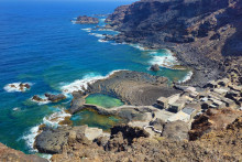 Leteck&yacute; pohľad na sopečn&eacute; pobrežie s tradičn&yacute;mi domami a pr&iacute;rodn&yacute;mi baz&eacute;nmi v Pozo de las Calcosas na ostrove El Hierro. FOTO: Dreamstime
