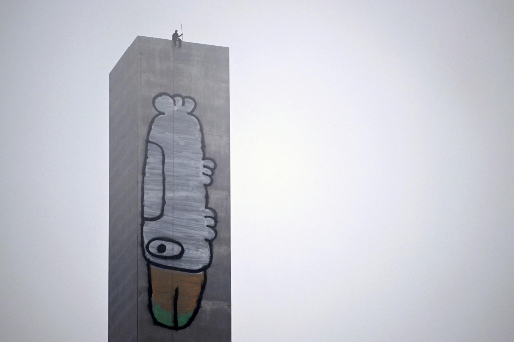 Graffiti umelec Jack Gibson-Burrell na 140-metrovej veži. FOTO: REUTERS/JOEL CARRETT
