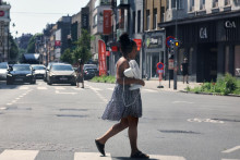 Žena kr&aacute;ča cez ulicu s ventil&aacute;torom počas vlny hor&uacute;čav v Bruseli. FOTO: TASR/AP