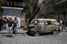 Pr&iacute;slu&scaron;n&iacute;ci s&yacute;rskych bezpečnostn&yacute;ch s&iacute;l sk&uacute;maj&uacute; obhoren&eacute; vozidlo neďaleko hotela Four Seasons po dvoch v&yacute;buchoch v s&yacute;rskom Damasku. FOTO: TASR/AP