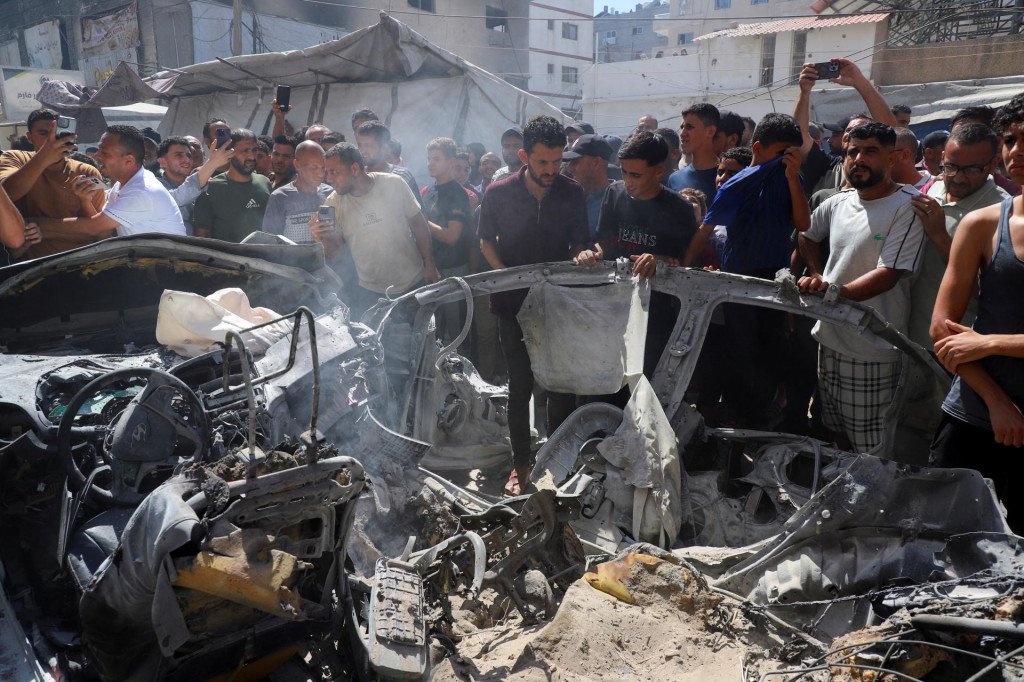 Palest&iacute;nčania kontroluj&uacute; miesto izraelsk&eacute;ho &uacute;toku na vozidlo v meste Gaza. FOTO: Reuters