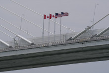 Kanadsk&eacute; a americk&eacute; vlajky vej&uacute; na moste Gordieho Howea vo f&aacute;ze v&yacute;stavby sp&aacute;jaj&uacute;ci Windsor v kanadskej provincii Ontario a americk&eacute; mesto Detroit. FOTO: TASR/AP