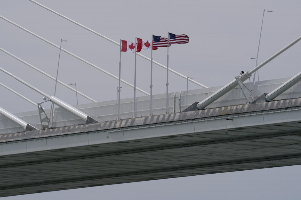 Kanadsk&eacute; a americk&eacute; vlajky vej&uacute; na moste Gordieho Howea vo f&aacute;ze v&yacute;stavby sp&aacute;jaj&uacute;ci Windsor v kanadskej provincii Ontario a americk&eacute; mesto Detroit. FOTO: TASR/AP