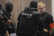 Na sn&iacute;mke obžalovan&yacute; Samuel Stra&scaron;ko prich&aacute;dza v sprievode pr&iacute;slu&scaron;n&iacute;kov Zboru v&auml;zenskej a justičnej str&aacute;že (ZVJS) na s&uacute;dne pojedn&aacute;vanie. FOTO: TASR/Martin Baumann