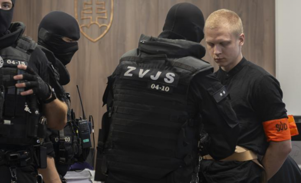 Na sn&iacute;mke obžalovan&yacute; Samuel Stra&scaron;ko prich&aacute;dza v sprievode pr&iacute;slu&scaron;n&iacute;kov Zboru v&auml;zenskej a justičnej str&aacute;že (ZVJS) na s&uacute;dne pojedn&aacute;vanie. FOTO: TASR/Martin Baumann
