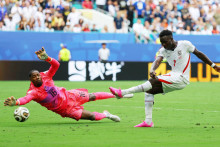 Bukayo Saka z Anglicka v s&uacute;boji s Franc&uacute;zom Mikem Maignanom predt&yacute;m, ako strelil tret&iacute; g&oacute;l. FOTO: Reuters