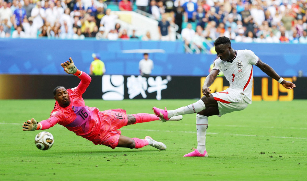 Bukayo Saka z Anglicka v s&uacute;boji s Franc&uacute;zom Mikem Maignanom predt&yacute;m, ako strelil tret&iacute; g&oacute;l. FOTO: Reuters