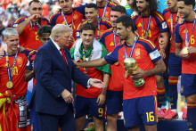 &Scaron;panielsky reprezentant Rodri sa rozpr&aacute;va s americk&yacute;m prezidentom Donaldom Trumpom, pričom drž&iacute; trofej z majstrovstiev sveta spolu so svojimi spoluhr&aacute;čmi, ktor&iacute; oslavuj&uacute; v&iacute;ťazstvo na Majstrovstv&aacute;ch sveta. FOTO: REUTERS
