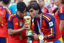 &Scaron;panieli Pedri a Ferran Torres bozk&aacute;vaj&uacute; trofej pri oslave v&iacute;ťazstva na MS vo futbale. FOTO: REUTERS