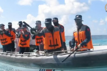 Na videosn&iacute;mke pr&iacute;slu&scaron;n&iacute;ci č&iacute;nskej pobrežnej str&aacute;že na nafukovacom člne s pevn&yacute;m trupom počas stretnutia s pr&iacute;slu&scaron;n&iacute;kmi filip&iacute;nskeho n&aacute;morn&iacute;ctva (nie s&uacute; na sn&iacute;mke) na plytčine Ayungin (v angličtine Second Thomas Shoal) na Spratlyho ostrovoch. FOTO: TASR/AP