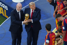 Americk&yacute; prezident Donald Trump a &scaron;&eacute;f Medzin&aacute;rodnej futbalovej feder&aacute;cie (FIFA) Gianni Infantino stoja s trofejou pri &scaron;panielskych futbalistoch, ktor&iacute; oslavuj&uacute; so zlat&yacute;mi medailami triumf na majstrovstv&aacute;ch sveta vo futbale. FOTO: TASR/AP