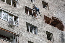 Pracovn&iacute;k kontroluje po&scaron;koden&yacute; bytov&yacute; dom po &uacute;toku ukrajinsk&eacute;ho dronu v meste Solnečnogorsk v Moskovskej oblasti v Rusku. FOTO: Reuters