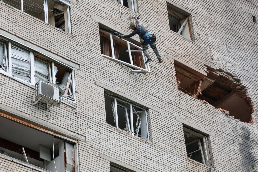 Pracovn&iacute;k kontroluje po&scaron;koden&yacute; bytov&yacute; dom po &uacute;toku ukrajinsk&eacute;ho dronu v meste Solnečnogorsk v Moskovskej oblasti v Rusku. FOTO: Reuters