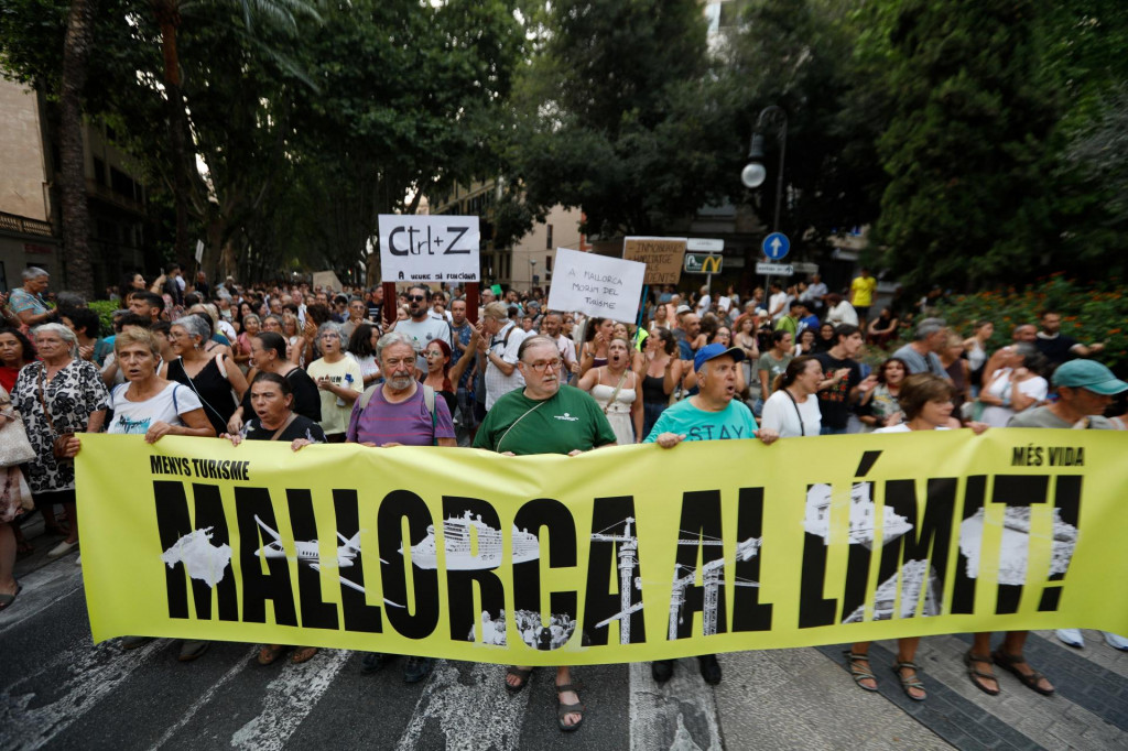 Demon&scaron;tranti nes&uacute; transparent počas protestu proti masov&eacute;mu turizmu v Palme de Mallorca. FOTO: Reuters