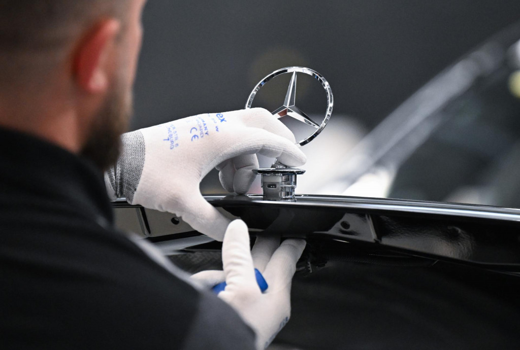 Na arch&iacute;vnej sn&iacute;mke zamestnanec automobilky Mercedes-Benz montuje hviezdu na vozidlo triedy S v z&aacute;vode Mercedes-Benz. FOTO: TASR/DPA