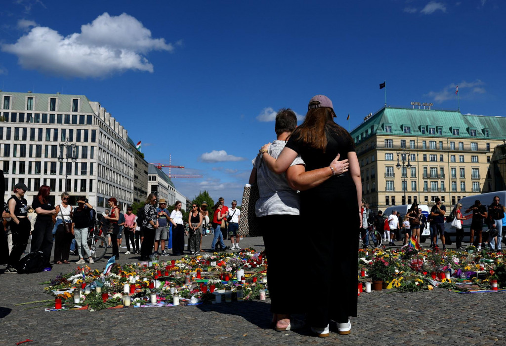 Ľudia nav&scaron;tevuj&uacute; proviz&oacute;rny pam&auml;tn&iacute;k pri Brandenburskej br&aacute;ne po smrteľnom &uacute;toku, pri ktorom vozidlo narazilo do davu neďaleko berl&iacute;nskeho každoročn&eacute;ho pochodu Pride. FOTO: Reuters