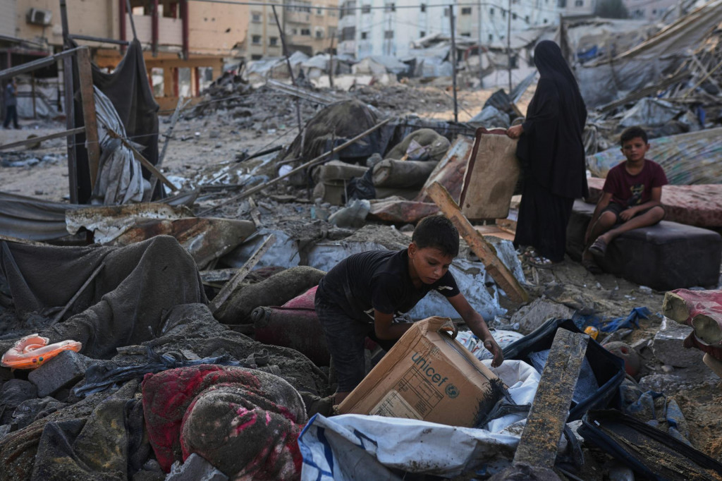 Palest&iacute;nčania zachraňuj&uacute; svoje osobn&eacute; veci z trosiek budovy a stanov, ktor&eacute; boli zničen&eacute; pri izraelskom leteckom &uacute;toku v meste Gaza. FOTO: TASR/AP