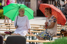 Na sn&iacute;mke ženy sa chr&aacute;nia d&aacute;ždnikmi pred Slnkom počas 2. ročn&iacute;ka Medzin&aacute;rodn&eacute;ho krajansk&eacute;ho festivalu v Martine v sobotu 1. augusta 2026. FOTO: TASR/Daniel Stehl&iacute;k