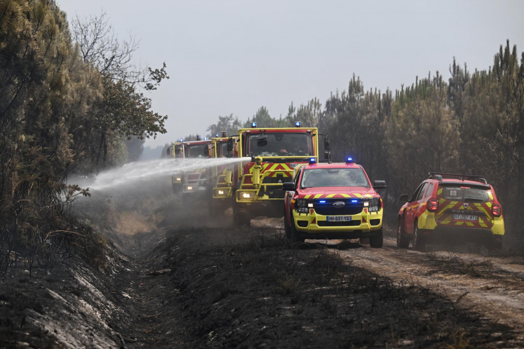 Hasiči polievaj&uacute; kr&iacute;ky vodou počas lesn&yacute;ch požiarov v obci Marcheprime neďaleko Bordeaux na juhoz&aacute;pade Franc&uacute;zska. FOTO: TASR/AP