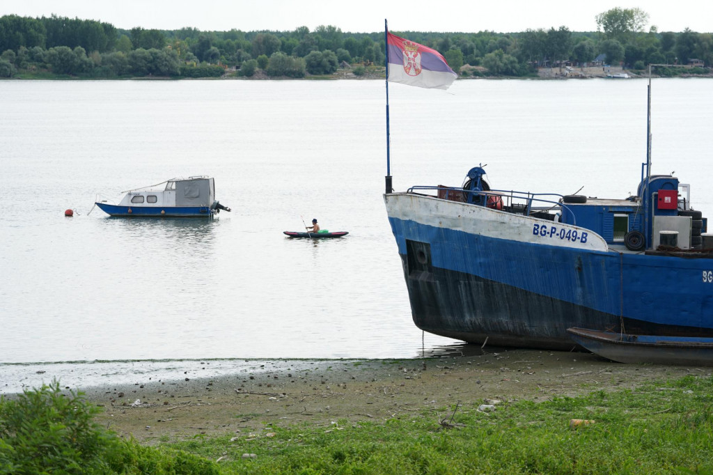 Muž vesluje popri vyschnutom brehu Dunaja po dlhom obdob&iacute; sucha v Belehrade. FOTO: TASR/AP