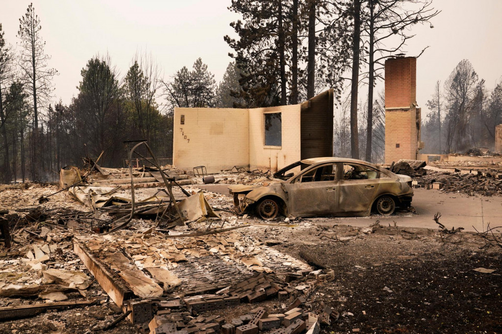 Zhoren&eacute; vozidlo lež&iacute; medzi pozostatkami domu počas lesn&yacute;ch požiarov v Spokane v &scaron;t&aacute;te Washington.  FOTO: Reuters