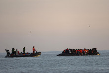 Ilustračn&aacute; fotografia. Franc&uacute;zski žand&aacute;ri na lodi sa bl&iacute;žia ku skupine migrantov na nafukovacom člne. FOTO: Reuters