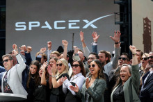 Členovia vedenia spoločnosti SpaceX a ich hostia oslavuj&uacute; na balk&oacute;ne v budove Nasdaq MarketSite v deň prvotnej verejnej ponuky akci&iacute; spoločnosti SpaceX v New Yorku 12. j&uacute;na 2026. FOTO: Reuters