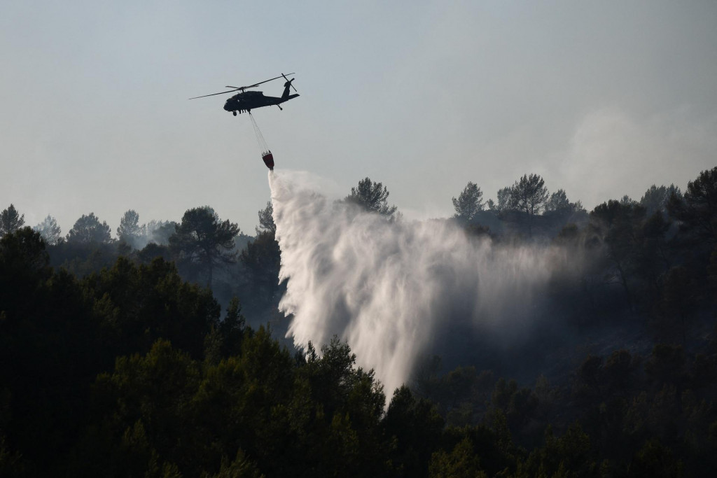 Hasičsk&yacute; vrtuľn&iacute;k zhadzuje vodu počas lesn&eacute;ho požiaru neďaleko Montfort-sur-Argens, neďaleko Correns, v departemente Var vo Franc&uacute;zsku. FOTO: Reuters