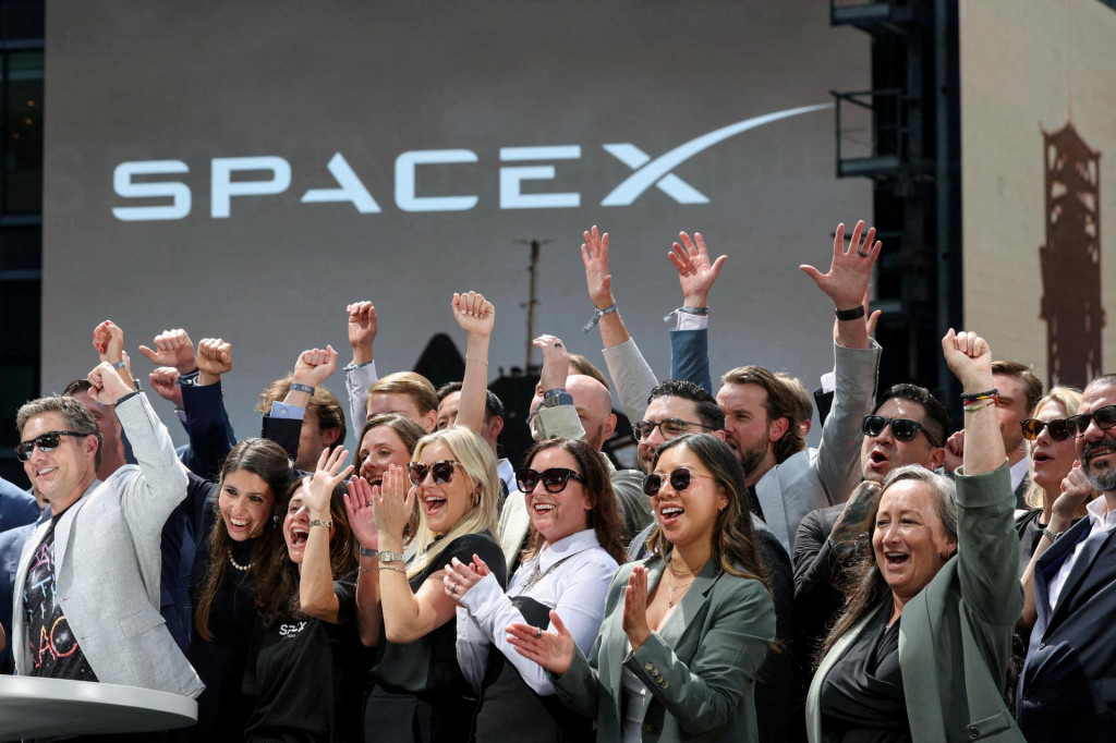 Členovia vedenia spoločnosti SpaceX a ich hostia oslavuj&uacute; na balk&oacute;ne v budove Nasdaq MarketSite v deň prvotnej verejnej ponuky akci&iacute; spoločnosti SpaceX v New Yorku 12. j&uacute;na 2026. FOTO: Reuters